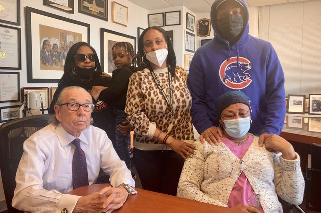 Eudes Pierre’s family in the office of their attorney, Sanford Rubenstein, who is seated at left.